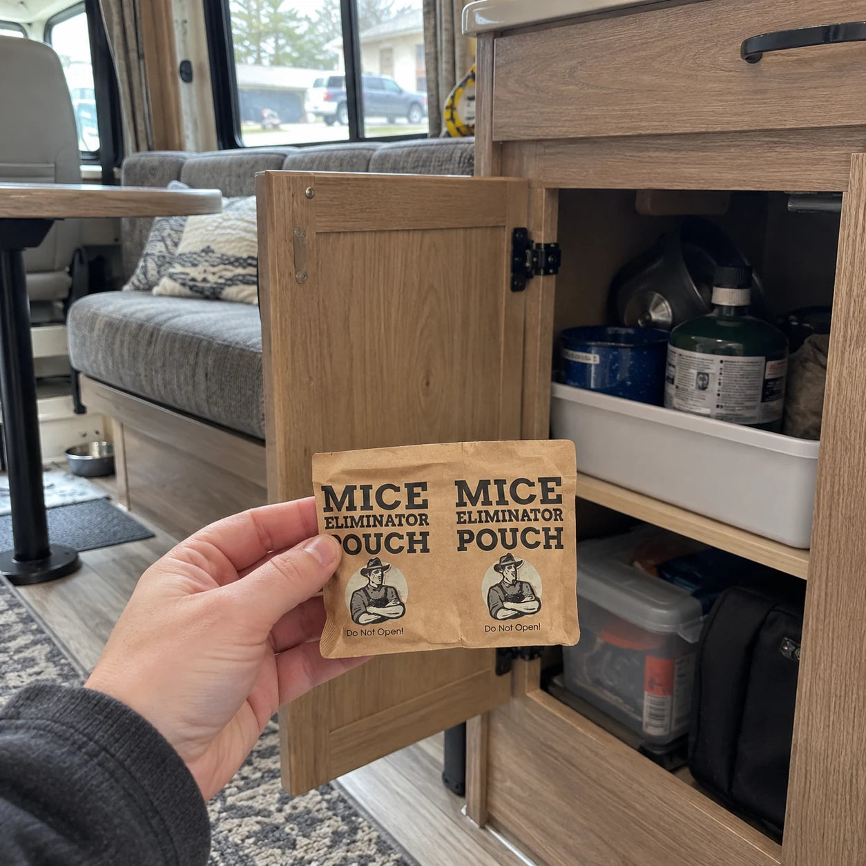 A pouch held beside an open cabinet inside a camper RV